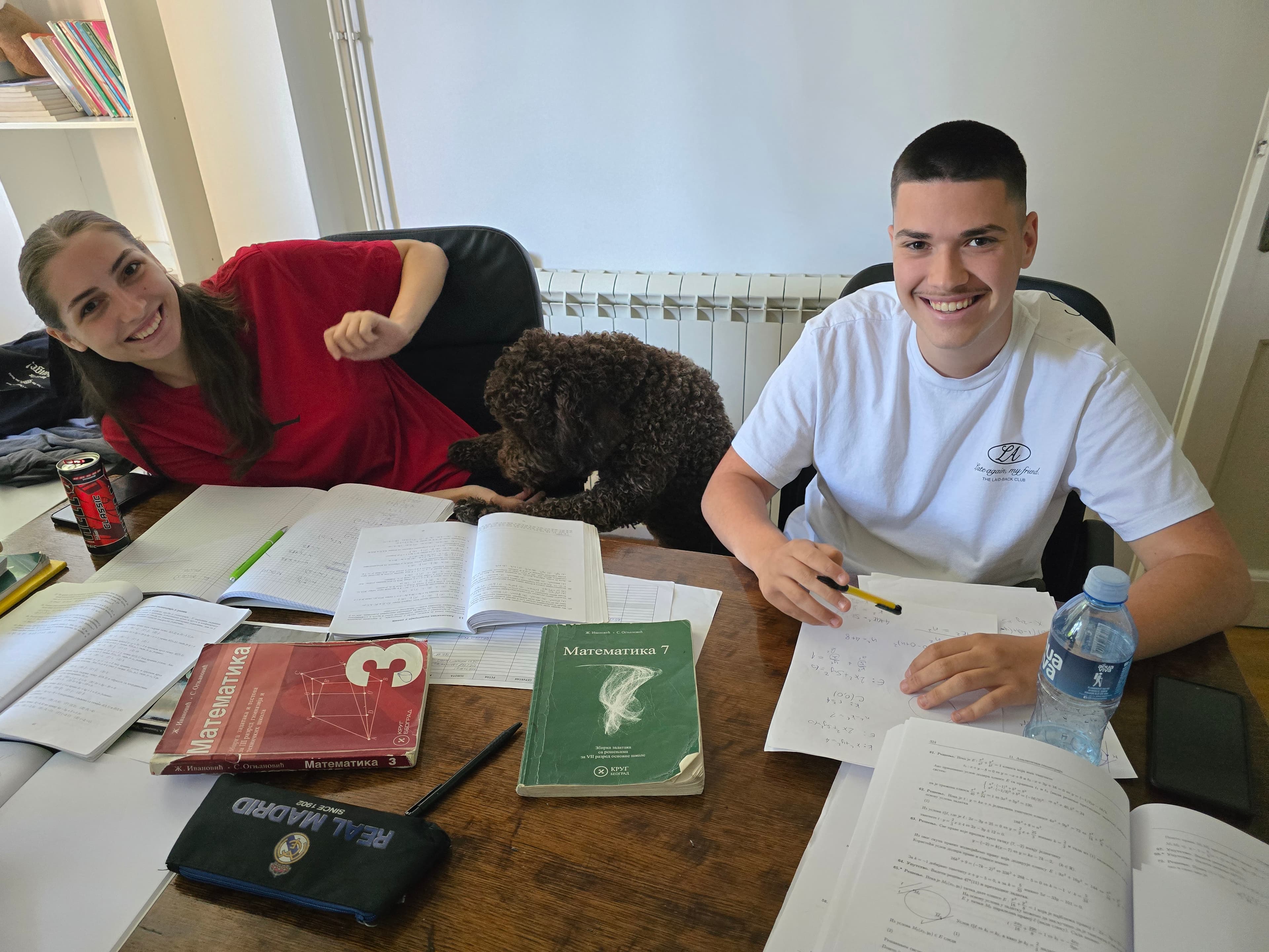 Dvoje učenika na času matematike, uz psa, u prijatnoj atmosferi